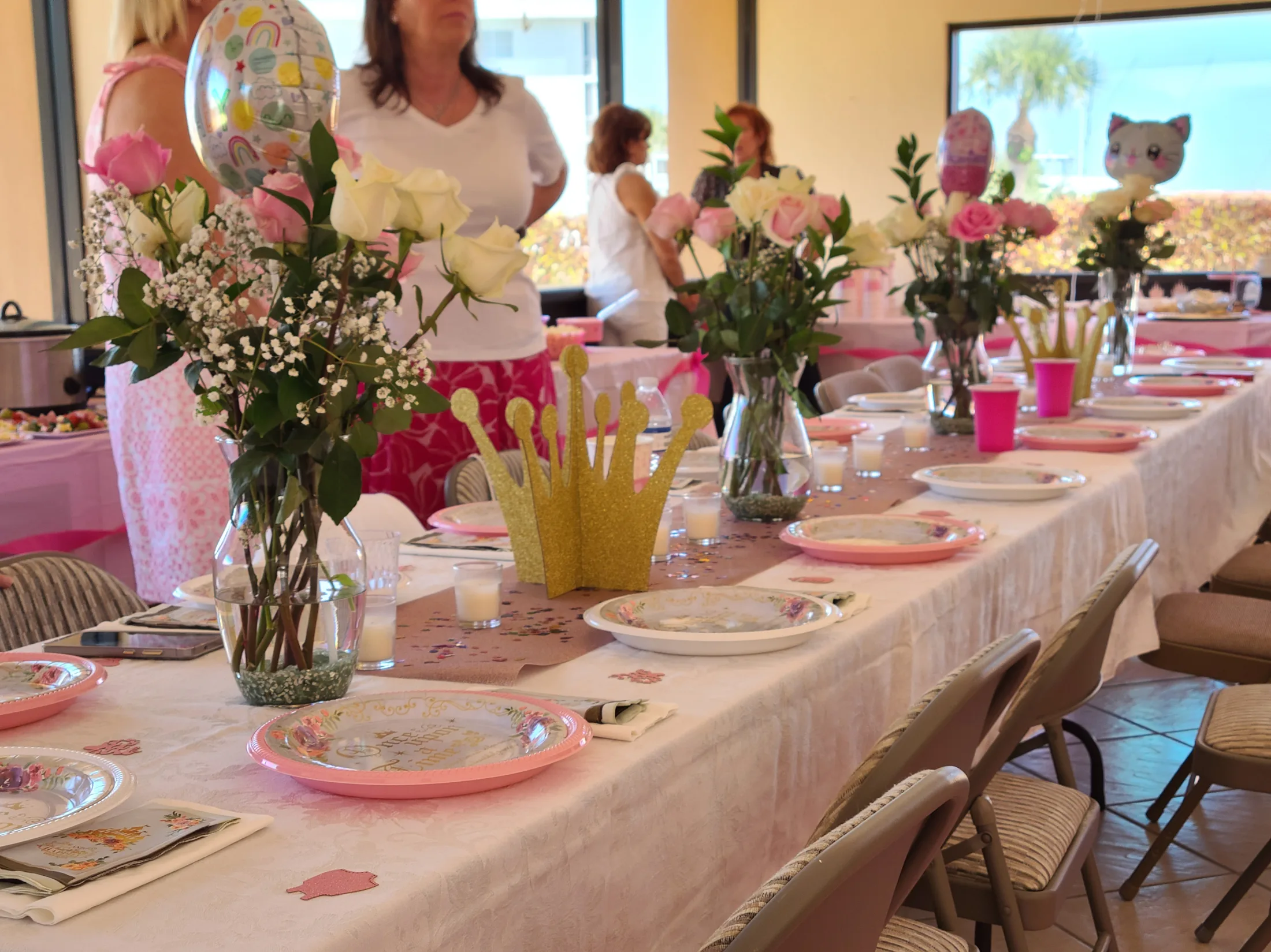 Baby shower guests enjoying a personalized photo game and signing book experience
