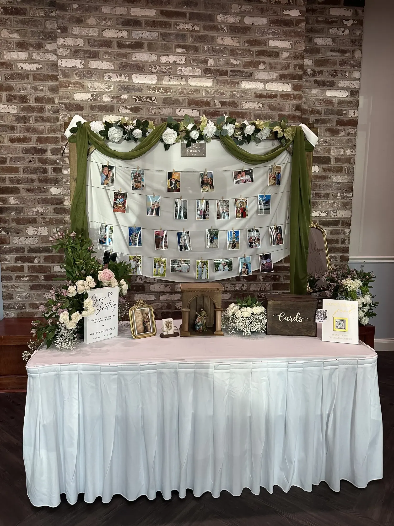 Wedding memory table display with framed photos, floral accents, cards box, and welcome signage
