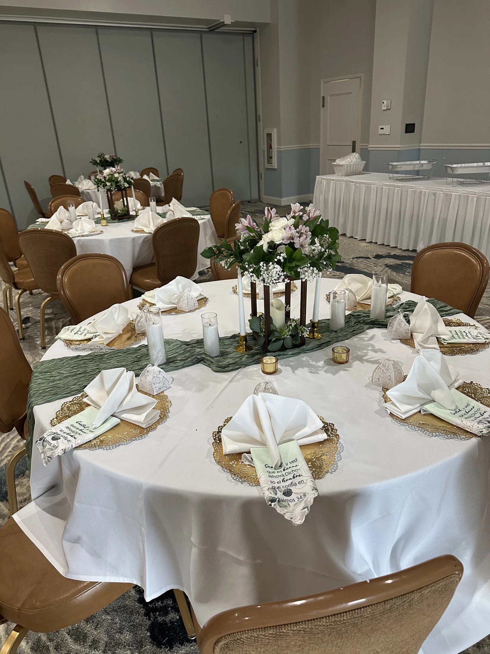 Wedding reception table design with floral centerpiece, candles, green runner, and place settings